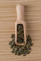 Image showing Wooden scoop with pumpkin seeds