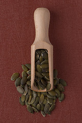 Image showing Wooden scoop with pumpkin seeds