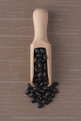 Image showing Wooden scoop with black beans