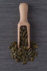 Image showing Wooden scoop with pumpkin seeds