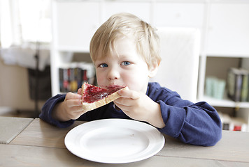 Image showing Boy eating bread and jam
