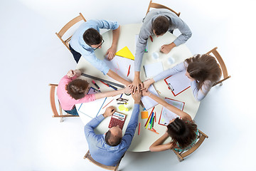 Image showing Top view. United hands of business team on workspace background 