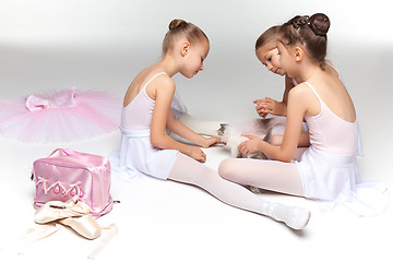 Image showing Three little ballet girls sitting and posing together