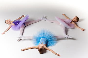 Image showing Three little ballet girls in tutu lying and posing together
