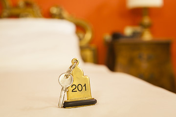 Image showing Hotel Room Key lying on Bed with keyring