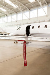 Image showing Airplane in Hangar with remove before flight Labels in red