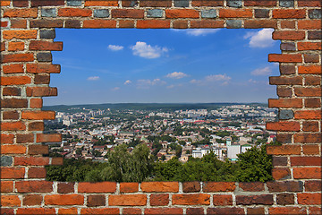 Image showing broken wall from red brick and view to the city