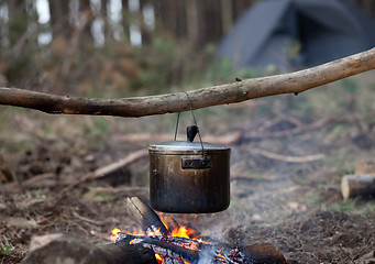 Image showing Cooking in sooty cauldron on campfire