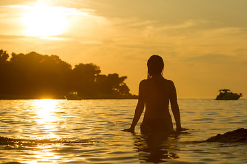 Image showing Woman standing in shallow at sunset