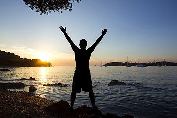 Image showing Man saluting sun at sea