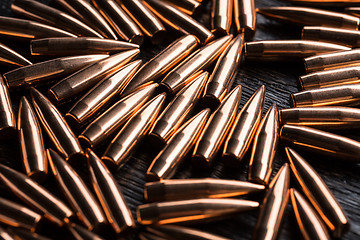 Image showing Placer copper bullets on a dark wooden background