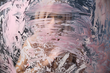 Image showing Portrait of seminude blonde through the glass smeared pink clay