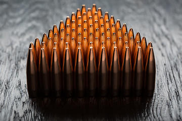 Image showing Macro shot of copper bullets that are in many rows to form a tri