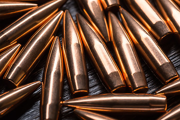 Image showing Placer copper bullets on a dark wooden background