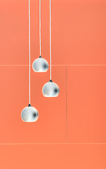 Image showing Orange negative collage of three ceiling lights, loft-style inte