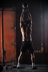 Image showing Beautiful athlete doing kettlebell swings