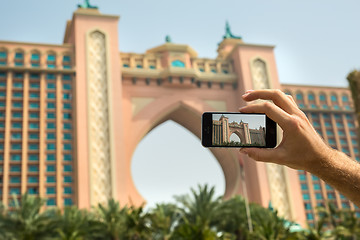 Image showing Hand tourist takes a picture of the hotel Atlantis Dubai on mobi