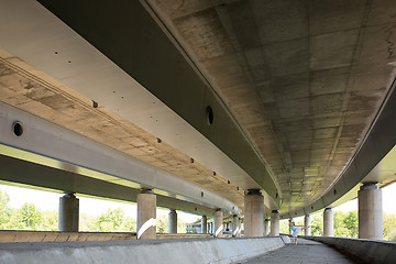 Image showing Graceful ballerina doing dance exercises on a concrete bridge 