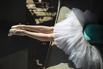 Image showing Ballerina sitting on the edge of bridge