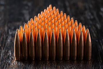 Image showing Macro shot of copper bullets that are in many rows to form a tri