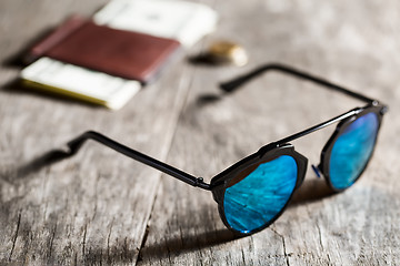 Image showing Stylish sunglasses with blue tinted mirror on textured wooden ba