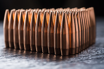 Image showing Macro shot of copper bullets that are in many rows to form a tri