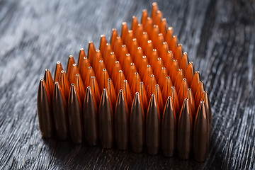 Image showing Macro shot of copper bullets that are in many rows to form a tri