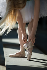 Image showing Dancer tying pointe shoes