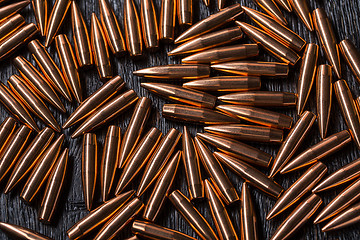 Image showing Placer copper bullets on a dark wooden background