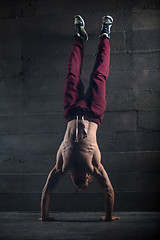 Image showing Athlete with naked torso doing push-ups on his hands