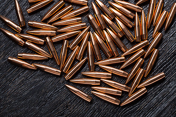 Image showing Placer copper bullets on a dark wooden background