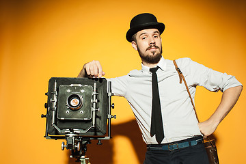 Image showing young man with retro camera 