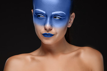 Image showing Portrait of a woman who is posing covered with blue paint