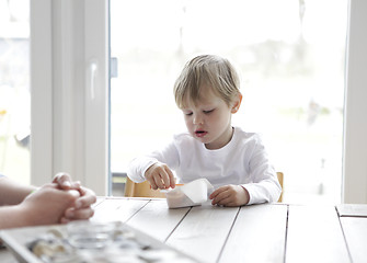 Image showing Boy eating yogurt at the table