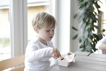 Image showing Boy eating yogurt