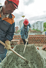 Image showing Workers knead solution for bricklayers