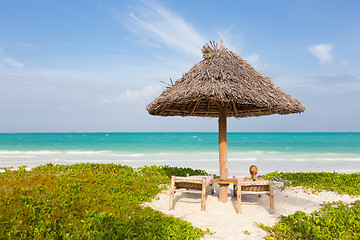 Image showing Woman sunbathing on tropical beach.