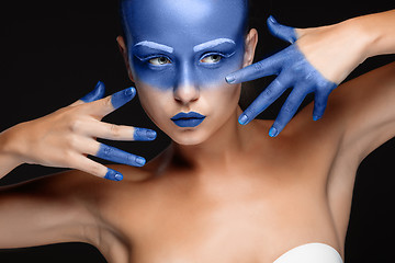 Image showing Portrait of a woman who is posing covered with blue paint