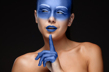 Image showing Portrait of a woman who is posing covered with blue paint