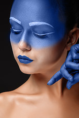 Image showing Portrait of a woman who is posing covered with blue paint