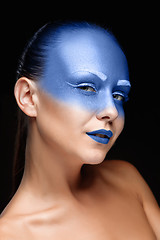 Image showing Portrait of a woman who is posing covered with blue paint