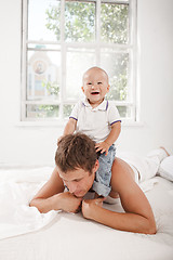 Image showing young father with his nine months old son on the bed at home