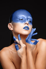 Image showing Portrait of a woman who is posing covered with blue paint