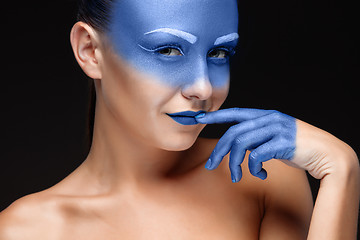 Image showing Portrait of a woman who is posing covered with blue paint