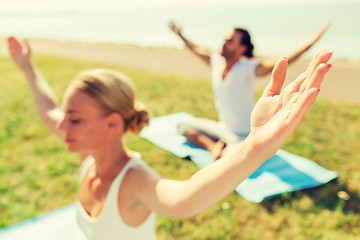 Image showing close up of couple making yoga exercises outdoors