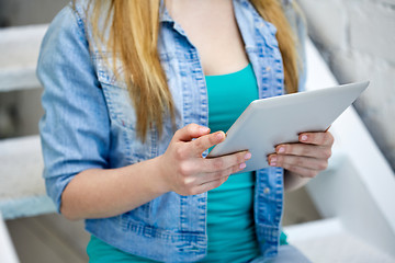 Image showing close up of female hands with tablet pc on stairs