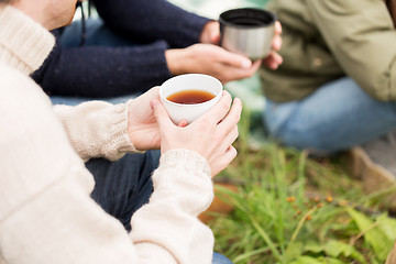 Image showing close up of hikers drinking tea from cups at camp