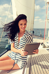 Image showing smiling woman sitting on yacht with tablet pc