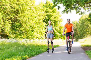 Image showing happy couple with rollerblades and bicycle riding