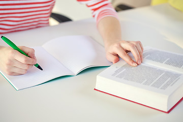 Image showing close up of female hands with book and notebook